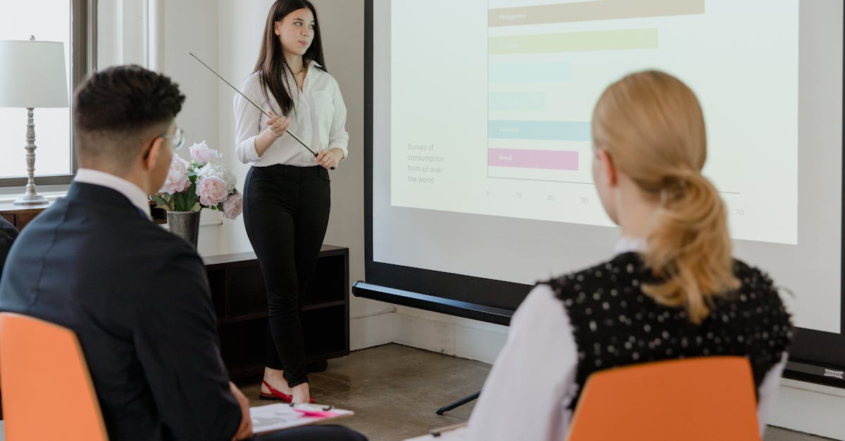 A young professional presenting data in a modern office to attentive colleagues.