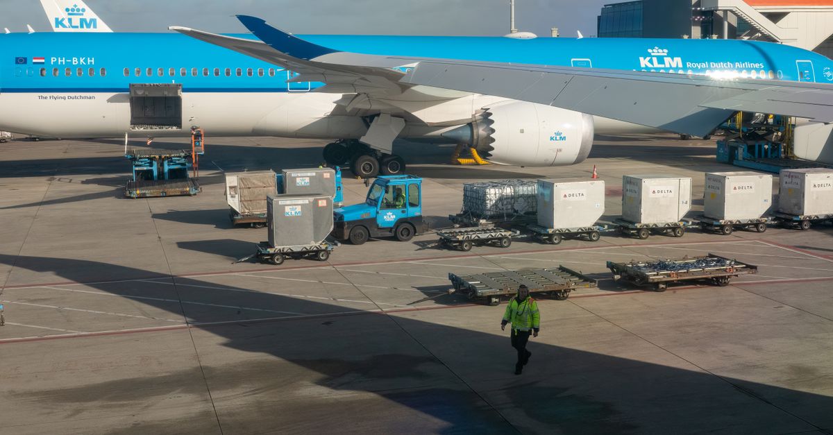 KLM aircraft preparing for departure on a sunny day with ground crew assisting.