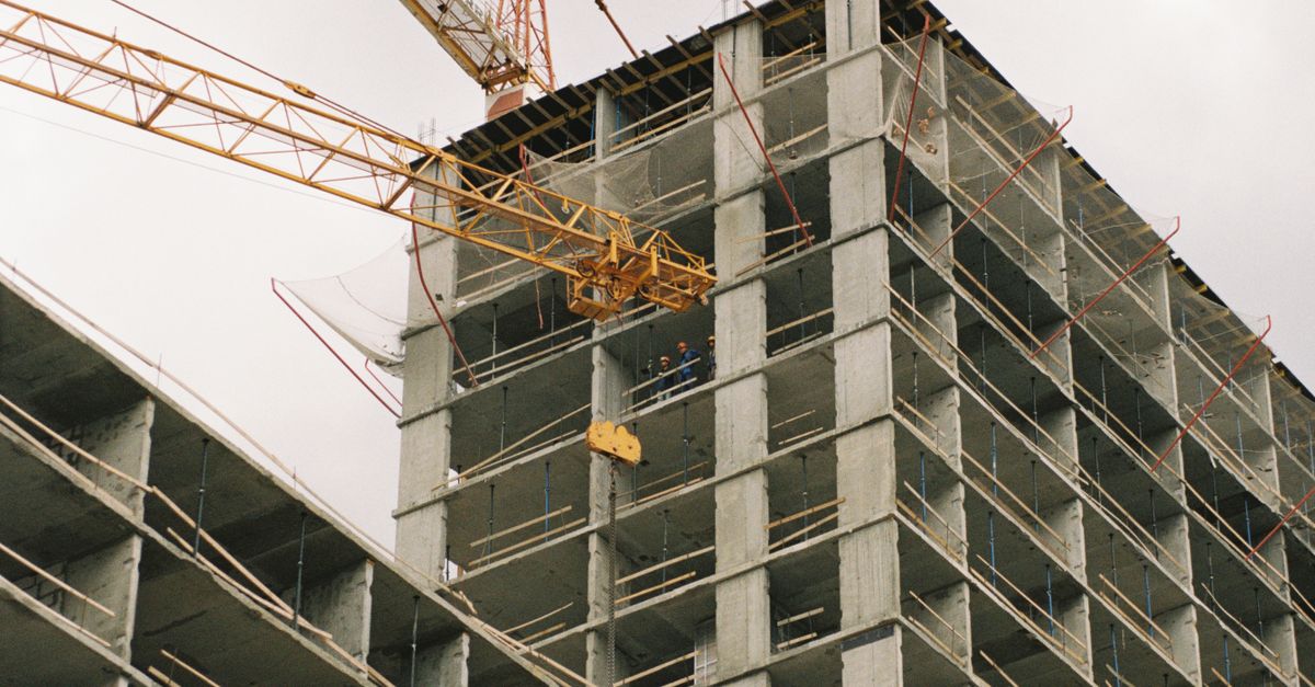 A towering construction site featuring a crane and concrete structure during its development phase.