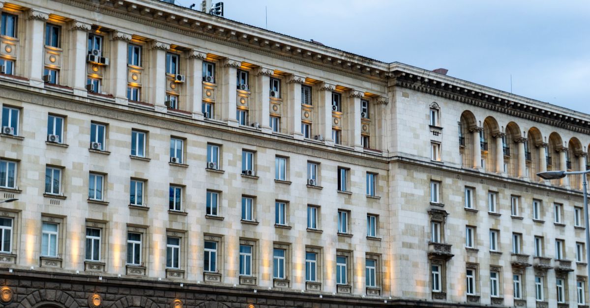 Illuminated government building in Sofia, showing classic architectural design under a twilight sky.