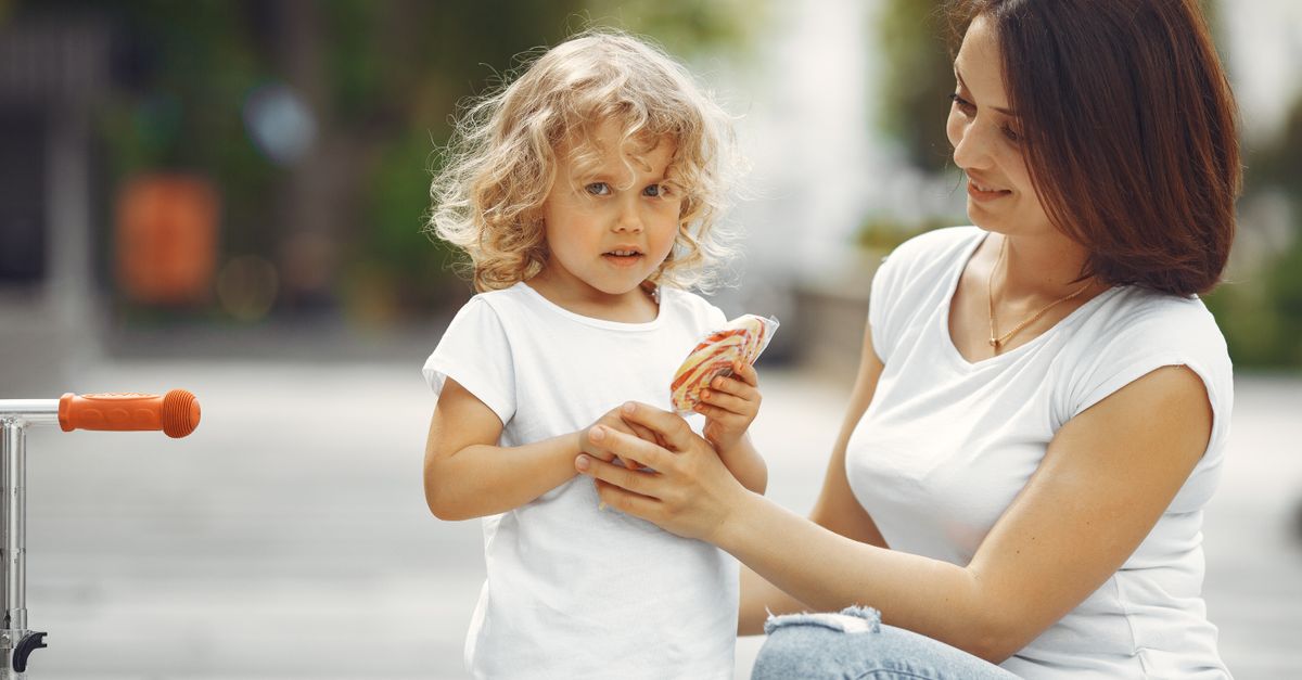 A mother and young daughter share a moment in an urban setting, highlighting family bonding.