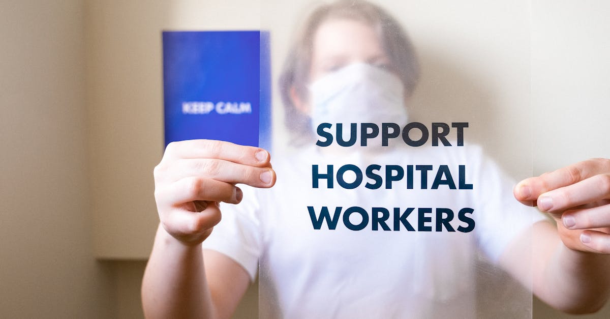 Person holding a support hospital workers sign, promoting health care and pandemic awareness.