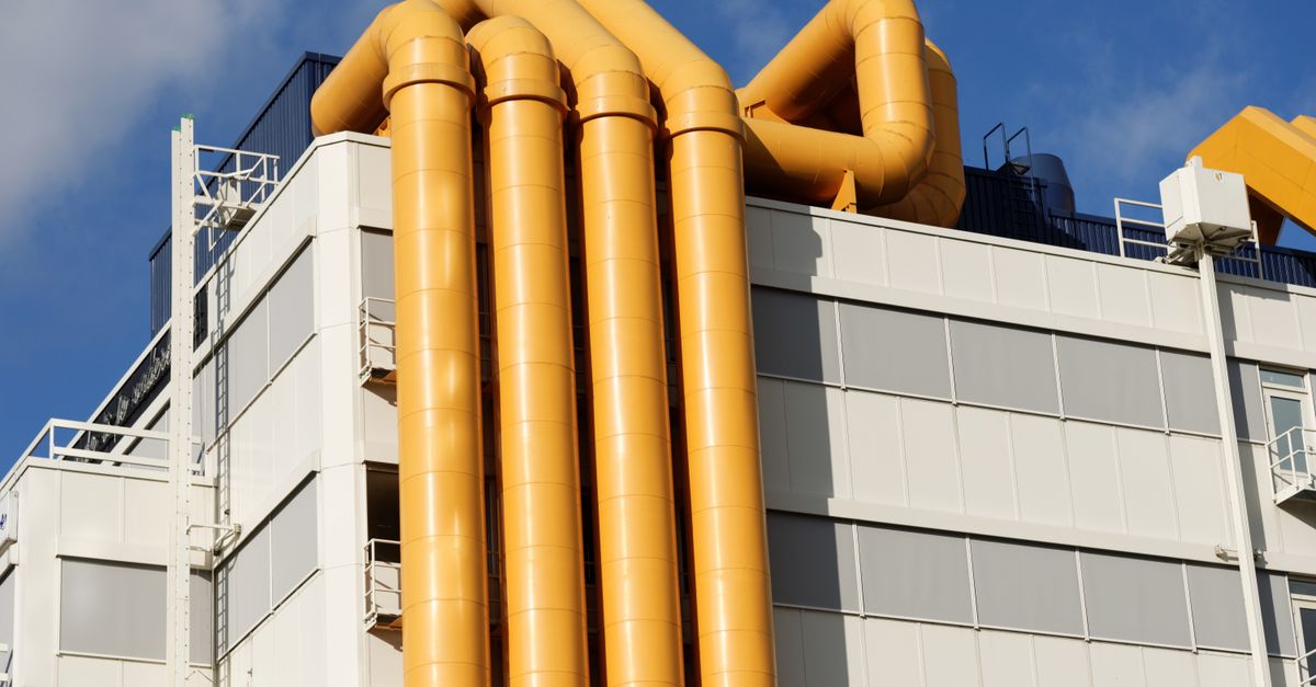 Close-up of a building facade in Rotterdam featuring striking yellow pipes.