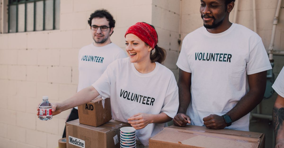 Volunteers distributing aid at an outdoor donation center, promoting social impact and diversity.