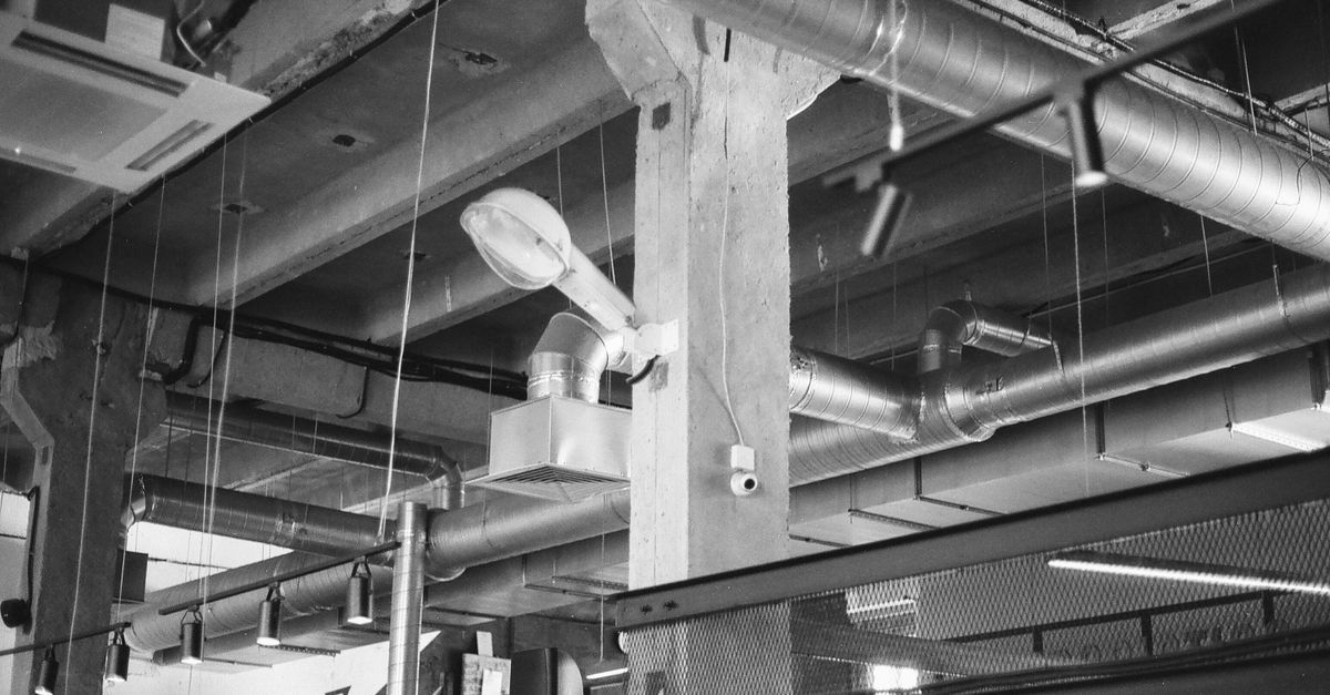 Black and white photo of industrial interior with exposed ducts and pipes in Saint Petersburg.