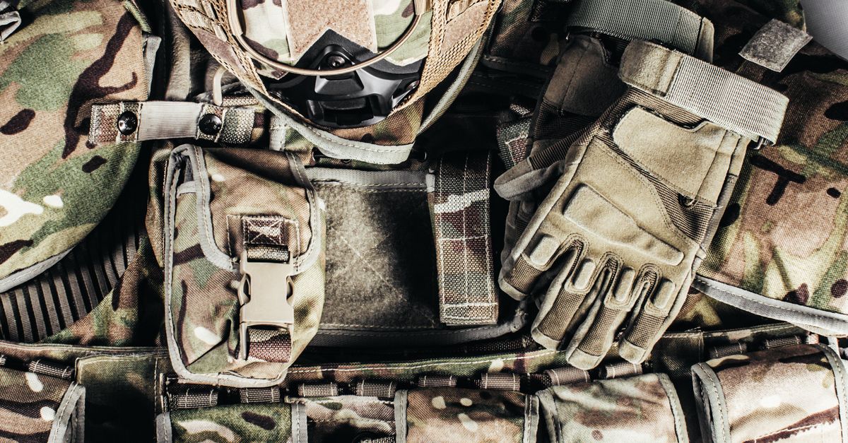 Close-up of tactical military gear with camouflage helmet and gloves showcasing readiness.