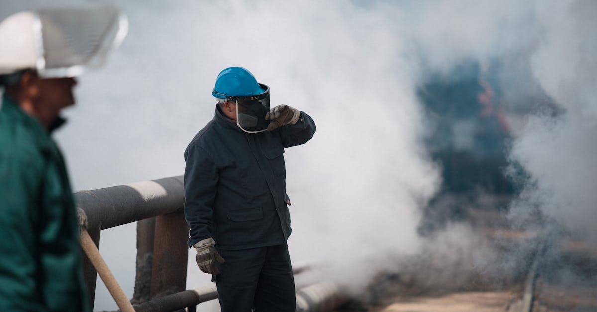Industrial workers wearing protective gear surrounded by heavy smoke, ensuring safety in harsh environments.