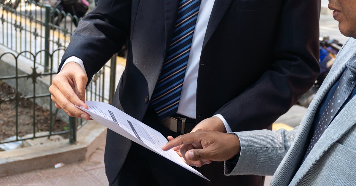 Two business professionals discussing and exchanging documents outdoors in Piura, Peru.
