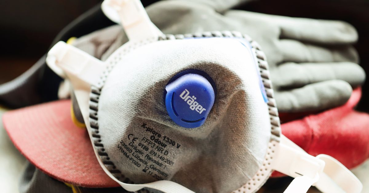 Close-up of a protective mask and work gloves on a building site.