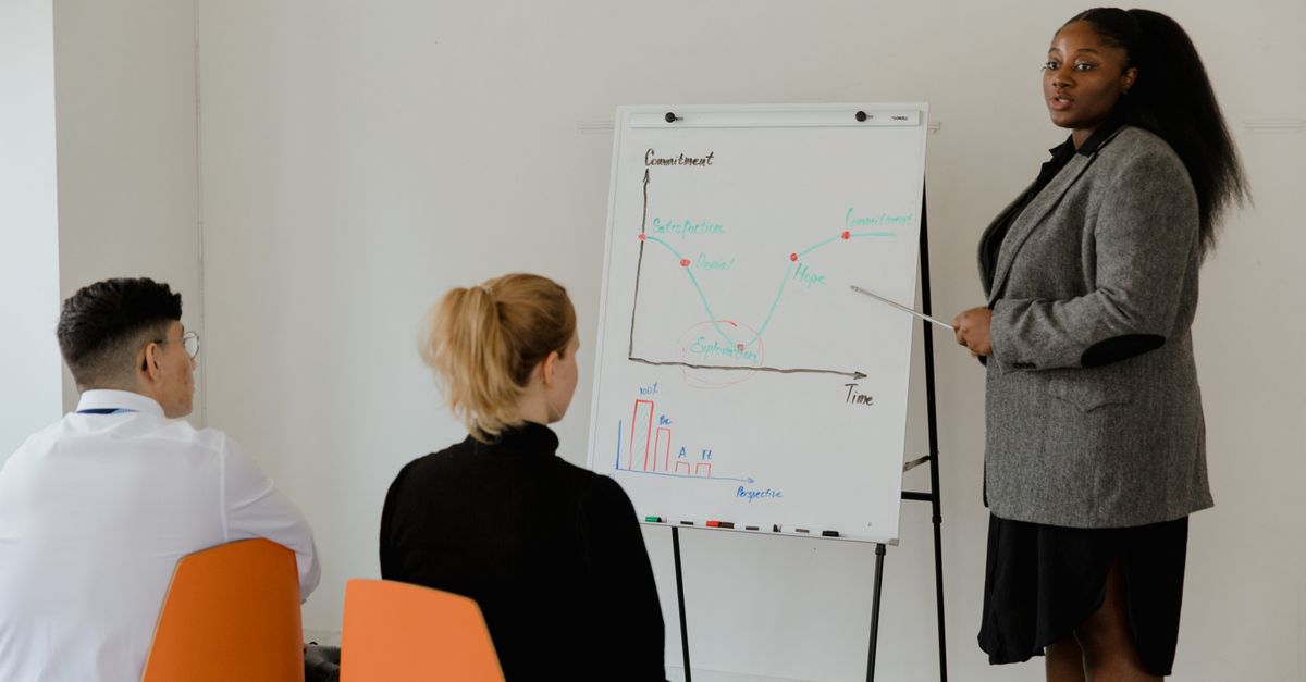 Professional woman presenting a business graph in a meeting.