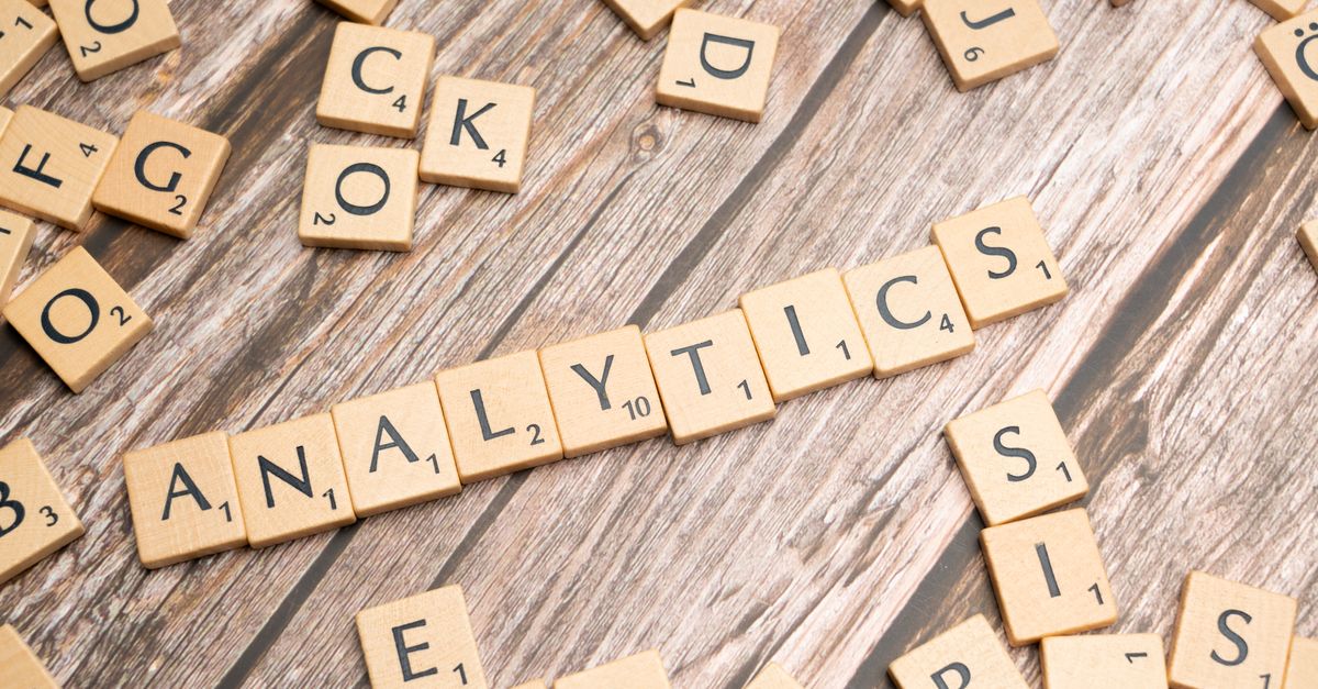 Scrabble tiles spelling 'Analytics' on a wooden surface, symbolizing data analytics concept.