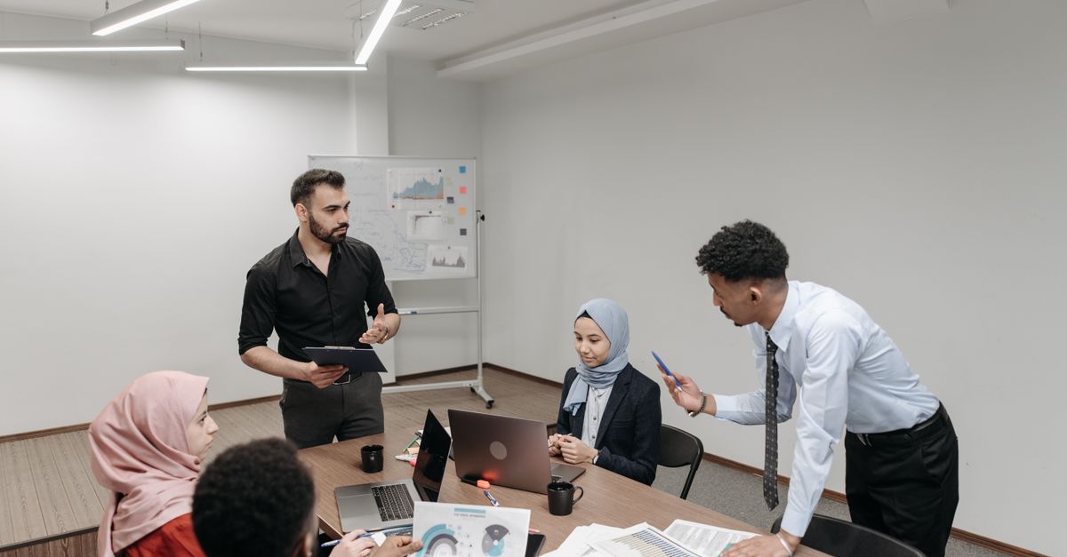 A diverse group of professionals engaged in a team meeting in a modern office setting.