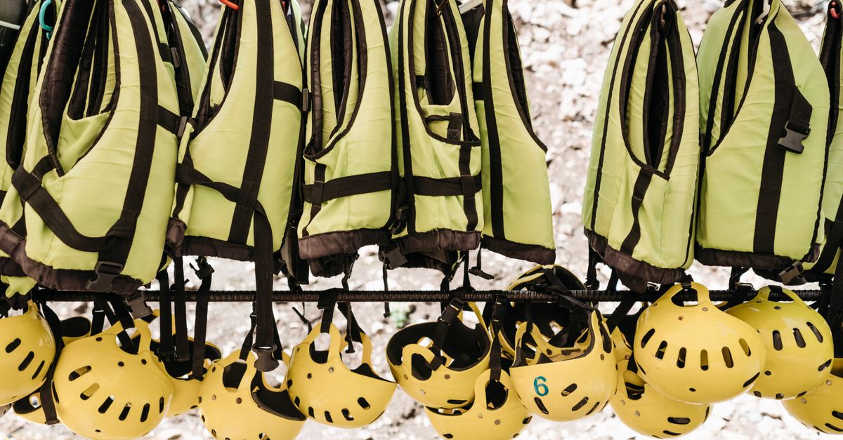Hanging safety vests and helmets for outdoor adventure activities.