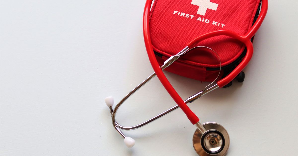 A red first aid kit paired with a stethoscope, signifying healthcare and medical treatment essentials.